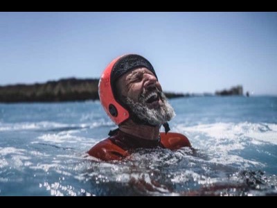 A coasteerer laughing in the water on an Anglesey Adventures session