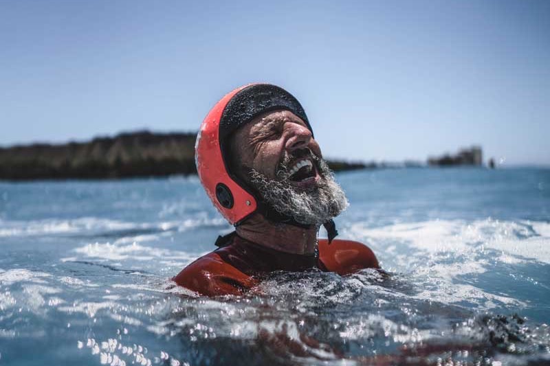 A coasteerer laughing in the water on an Anglesey Adventures session